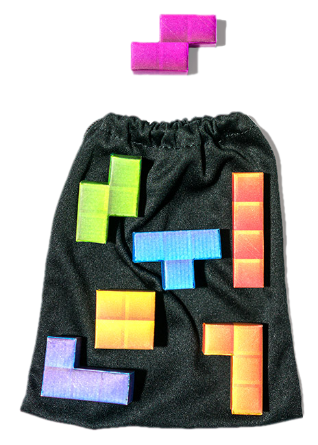 A black bag laying flat on a surface, six of the seven tetrominoes from the game Tetris are overlayed on the bag, and one appears outside of the bag.
